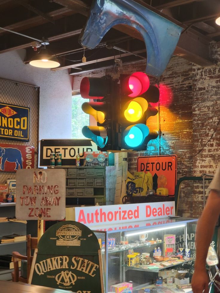 a man standing in front of a store filled with different types of signs and lights