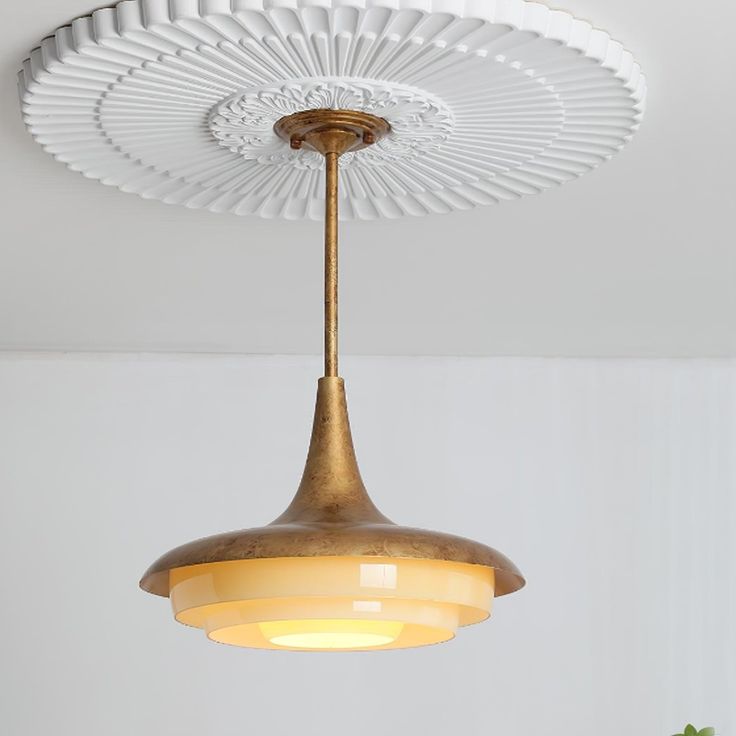 a light fixture hanging from the ceiling in a room with white walls and flooring