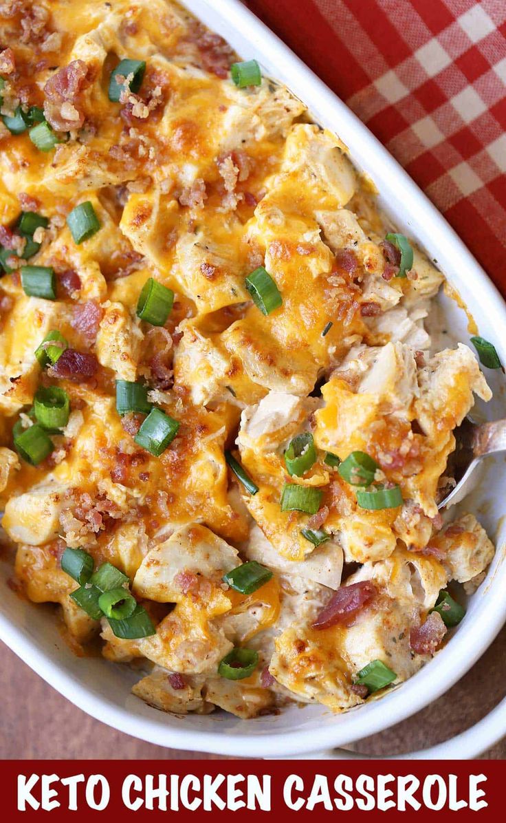 chicken casserole with green onions and bacon in a white dish on a red checkered tablecloth