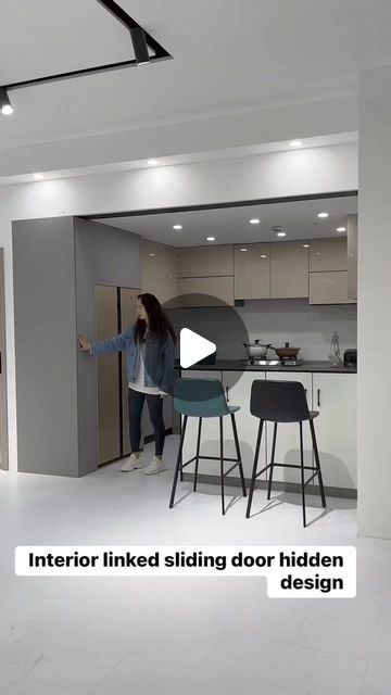 a woman standing in a kitchen next to a counter top oven and microwave with the words, interior linked sliding door hidden design