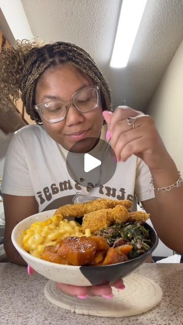 a woman is holding a bowl full of food