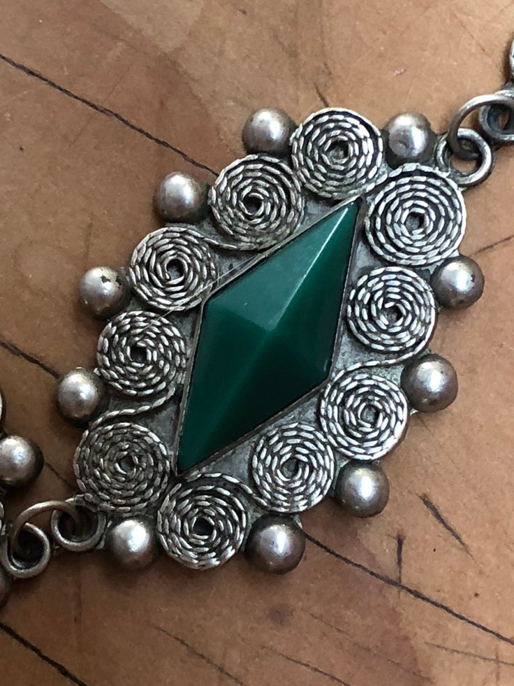 This three panel jade pendant is cut in a traditional Mexican style. attached to an intricate sterling silver necklace chain. The pendant's facial design, reminiscent of the ancient Aztec style, adds a curious twist to this extravagant and remarkable accessory. Necklace Length: 19.5 In Pendant Width: 1.5 in Pendant Height: 2 in Carved Silver Jade Jewelry, Silver Carved Jade Jewelry, Carved Silver Jade Necklaces, Carved Silver Jade Necklace, Carved Jade Necklace In Silver, Traditional Silver Jade Jewelry, Traditional Jade Medallion Jewelry, Facial Design, Ancient Aztecs