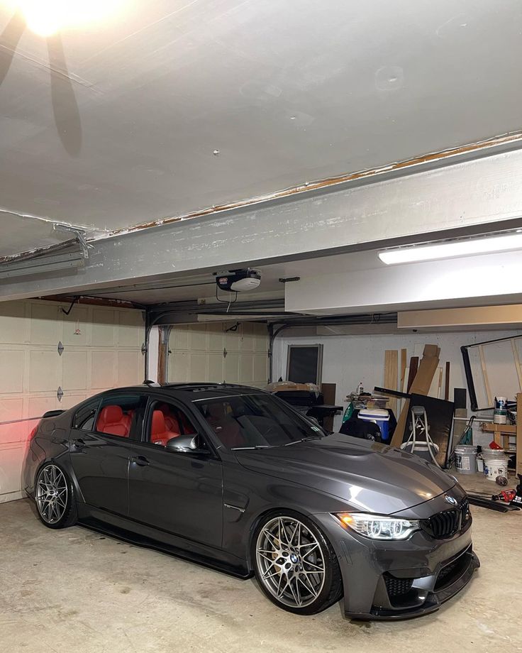 a grey car parked in a garage next to a wall