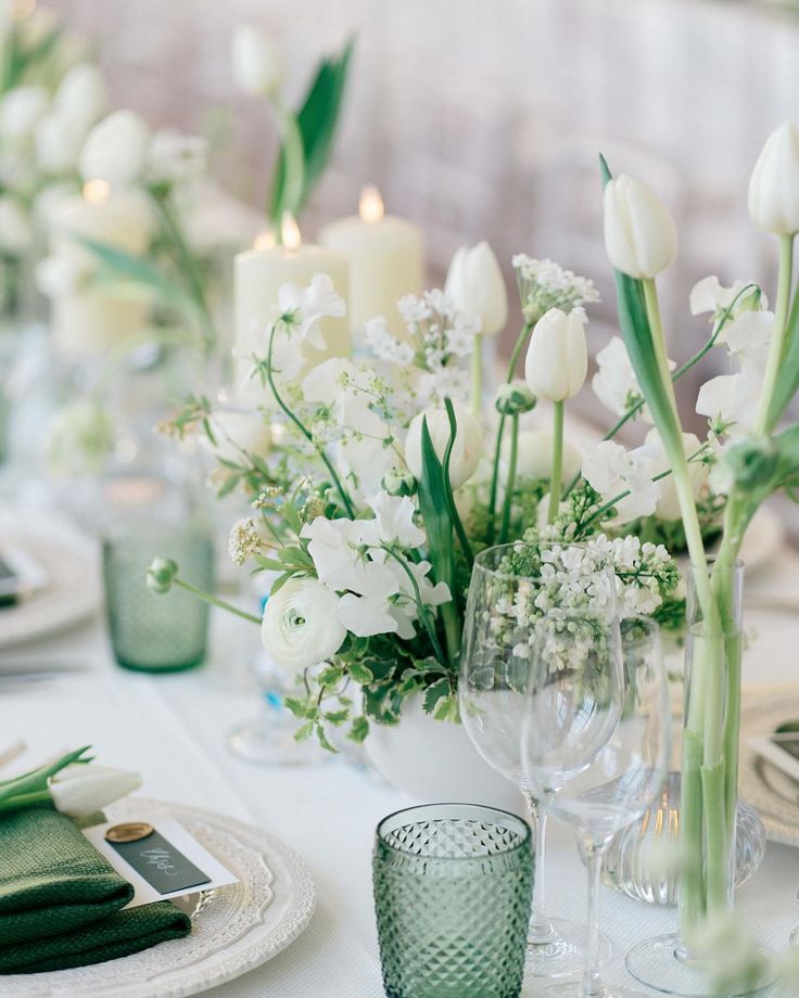 the table is set with white flowers and candles