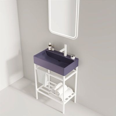 a white sink sitting under a bathroom mirror next to a purple counter top with two rolls of toilet paper on it