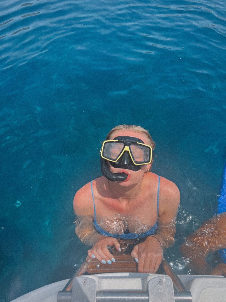 two people wearing goggles and snorkels on a boat in the water