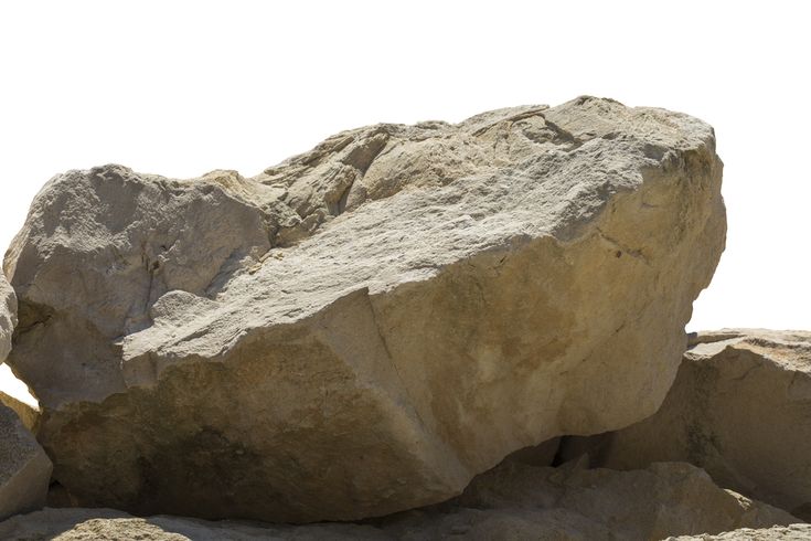 a large rock sitting on top of a pile of rocks next to a white sky