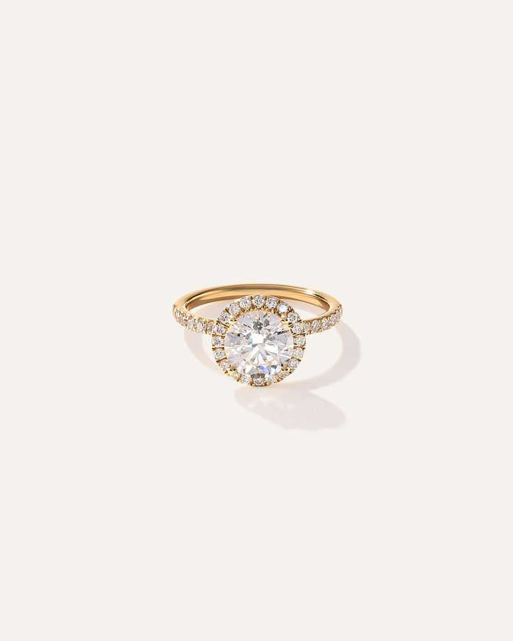 a gold ring with an oval shaped diamond surrounded by small round diamonds on the band