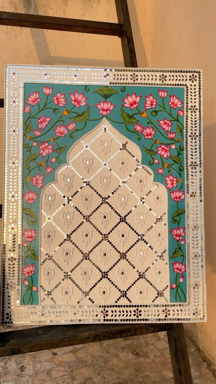 an intricately decorated tile sits on a stepladder in front of a wall