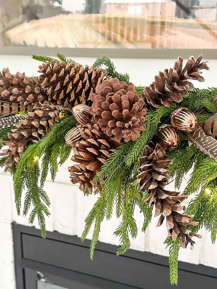 some pine cones are hanging from a mantel