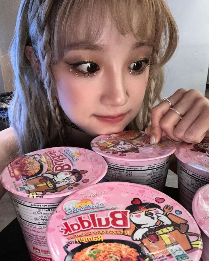 a girl with blonde hair is holding up some ice creams in front of her face