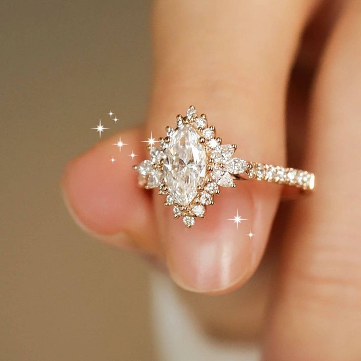 a woman's hand holding an engagement ring with diamonds on the band and side