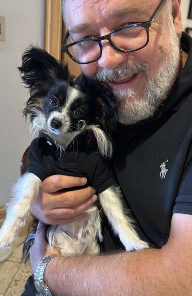 a man holding a small dog in his arms