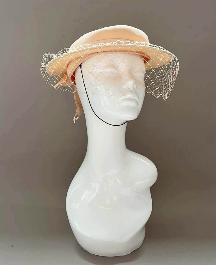 "Classic vintage hat. Perfect for Ascot, weddings, special occasions, very elegant. Comes with elastic to hold hat in place. Condition: vintage perfect Colour: peach  Label: Made in England Material: polyester Size: M inner circumference aprox. 21.5-22 inches, circumference 44\"\" *Please note all hats come securely packed in a box *All our vintage items come in clean and best condition possible *Please note all hats come securely packed in a box *All our vintage items are top quality authentic vintage accessories from private collections as well as ex-stage items from acclaimed milliners and manufactures. Accessories come in clean and best condition possible. PLEASE READ CAREFULLY We are trying hard to provide our customers with an excellent service and bring quality and rare vintage to t Cream Cloche Fascinator For Summer, Adjustable Cream Hat For Evening, Summer Wedding Cream Cloche Hat, Cream Cloche Hat For Summer Church Events, Vintage Cream Fascinator For Evening, Vintage Summer Evening Fascinator, Beige Cloche Hat For Church, Beige Brimmed Cloche Hat For Church, Summer Cream Cloche Hat For Church