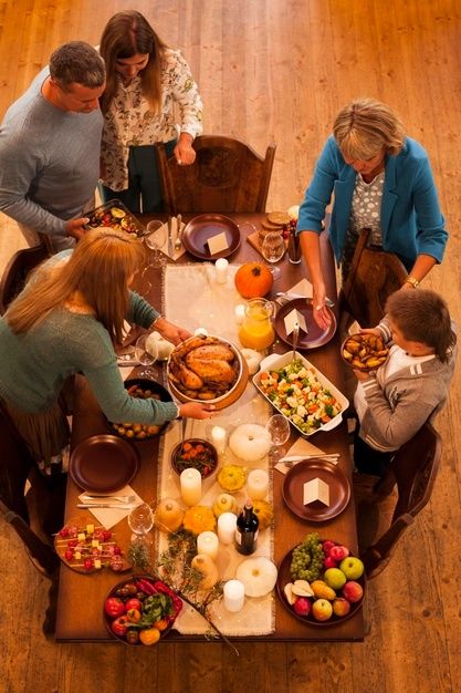 a group of people sitting around a table with food