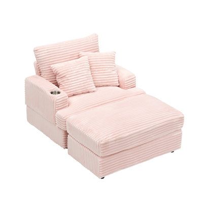 a pink corded couch with pillows on it's back and footrests