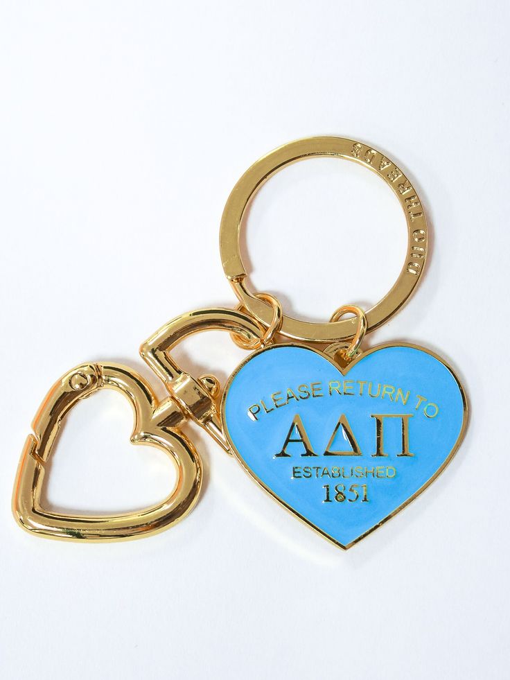 a blue heart shaped keychain with the word fraternity and two hearts attached to it