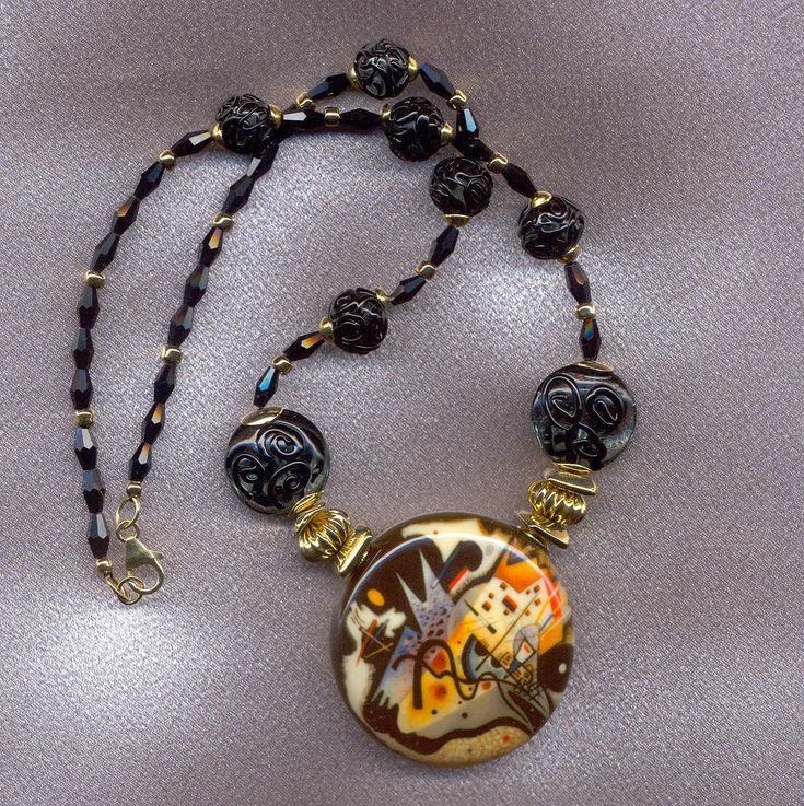 "I made this Murano Glass necklace to show the large, blown glass disc with Kandinsky's art piece, \"In the Black Circle\" on the front. The blown, Murano glass disc is approximately two inches wide, or 50mm wide by 18mm thick. Each blown disc is handmade, and therefore, will vary a little in size. The Venetian glass beads on this Kandinsky necklace have a base color of gray Murano glass, with a \"lacy scroll\", black, pattern on top of the gray. There are two, 20mm Venetian bead discs, and six Black Glass Necklaces, Black Round Glass Necklaces, Artistic Round Glass Necklaces, Murano Glass Beaded Necklace Gift, Czech Glass Beaded Necklace With Polished Beads, Artisan Black Round Necklace, Round Czech Glass Necklaces With Polished Beads, Round Czech Glass Necklaces With Large Beads, Czech Glass Polished Beads Round Necklaces