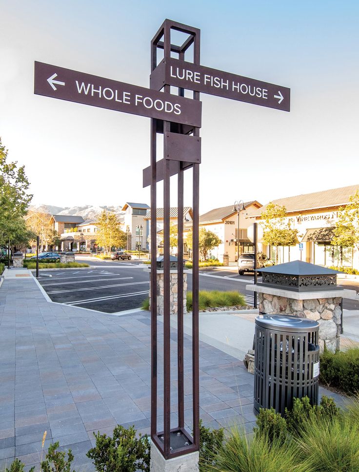 there is a sign that points in the direction of where fish house and whole foods are located