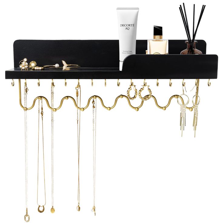 a black shelf with gold chains hanging from it's sides and various items on top