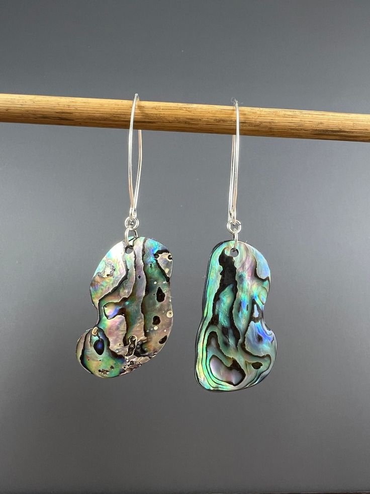 "A beautiful rainbow of color in this pair of Abalone shell earrings. Very lightweight and easy to wear all day.  Measure approx 2 1/4\" long Ear wires and findings are sterling silver.  Abalone jewelry is made using natural shell. I do not clear coat them. They are polished with natural food grade oil only. This pair is naturally shaped by the ocean." Unique Silver Shell Earrings, Unique Iridescent Pierced Earrings, Unique Iridescent Earrings, Iridescent Sterling Silver Earrings For Pierced Ears, Iridescent Sterling Silver Pierced Earrings, Adjustable Iridescent Drop Earrings, Iridescent Sterling Silver Earrings, Nickel-free Sterling Silver Shell-shaped Earrings, Unique Nickel-free Shell-shaped Earrings