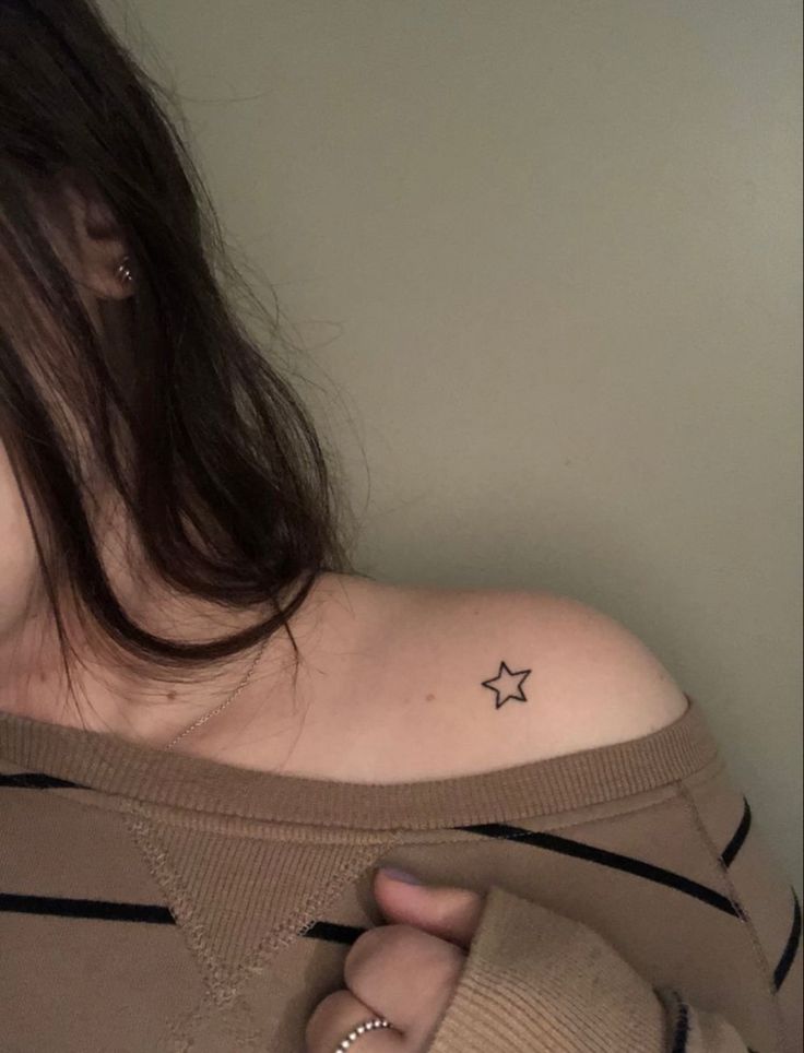 a woman with a small star tattoo on her left upper arm and right lower arm