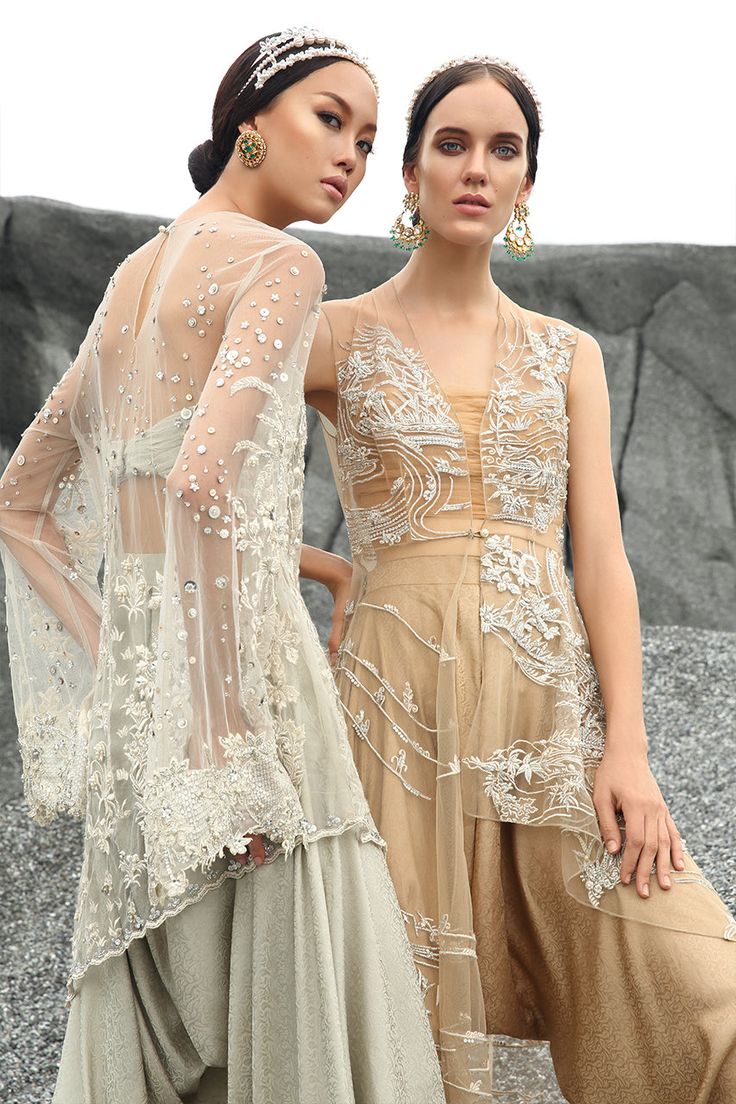 A dreamy gold shade of net is composed of embroidered snippets of Japanese-inspired florals and flowing water imagery. The A-symmetrical front open shirt is paired with a tonal ruched tube top and a voluminous draped jamawar box shalwar. Elegant Sheer Summer Sets, Summer Reception Dress With Sheer Dupatta, Elegant Reception Tops With Dupatta, Elegant Tops With Dupatta For Reception, Silk Wedding Top With Dupatta, Silk Top With Dupatta For Wedding, Silk Dupatta Top For Wedding, Fitted Tops For Spring Reception, Elegant Traditional Drape Summer Blouse