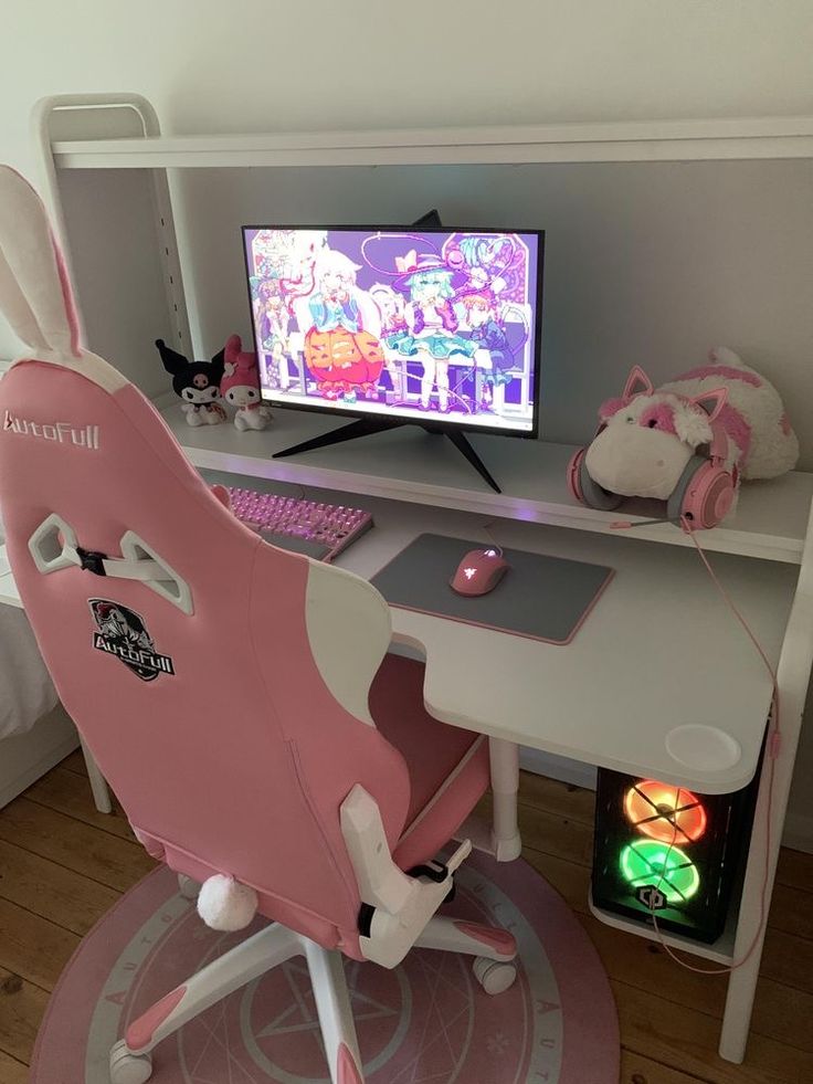 a desk with a computer monitor, keyboard and mouse in front of it on top of a pink chair