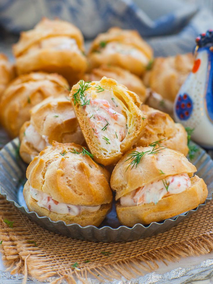 a plate full of pastries on a table next to a blue and white vase