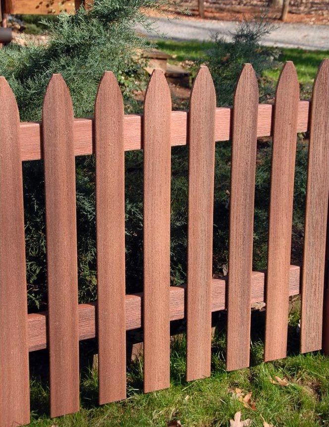 a close up of a wooden fence in the grass