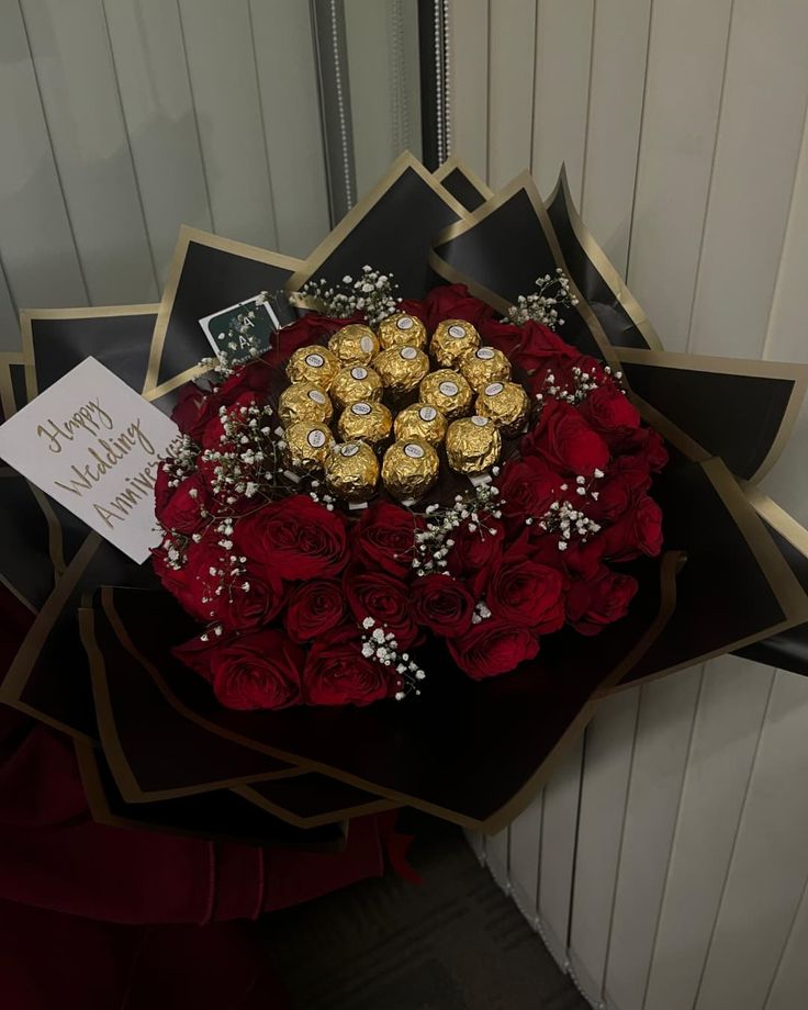 a bouquet of red roses and chocolates on display