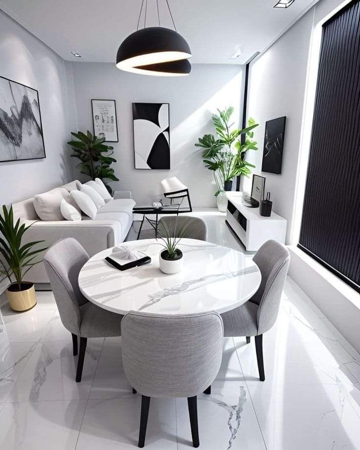 a modern living room with white walls and marble table surrounded by grey chairs, black framed art on the wall