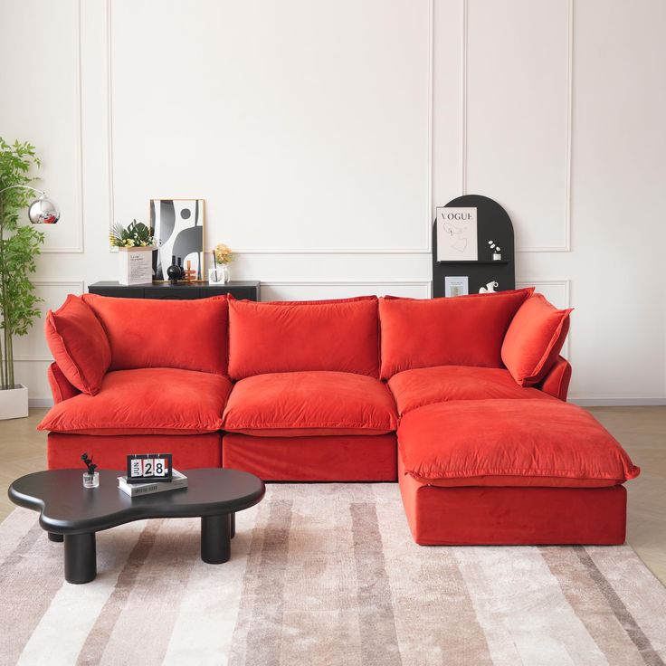 a living room with an orange couch and coffee table in front of the sectional sofa