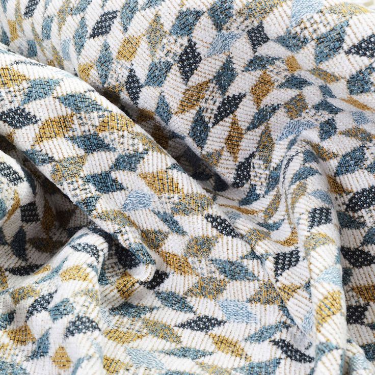 an up close shot of a blue, yellow and white patterned fabric