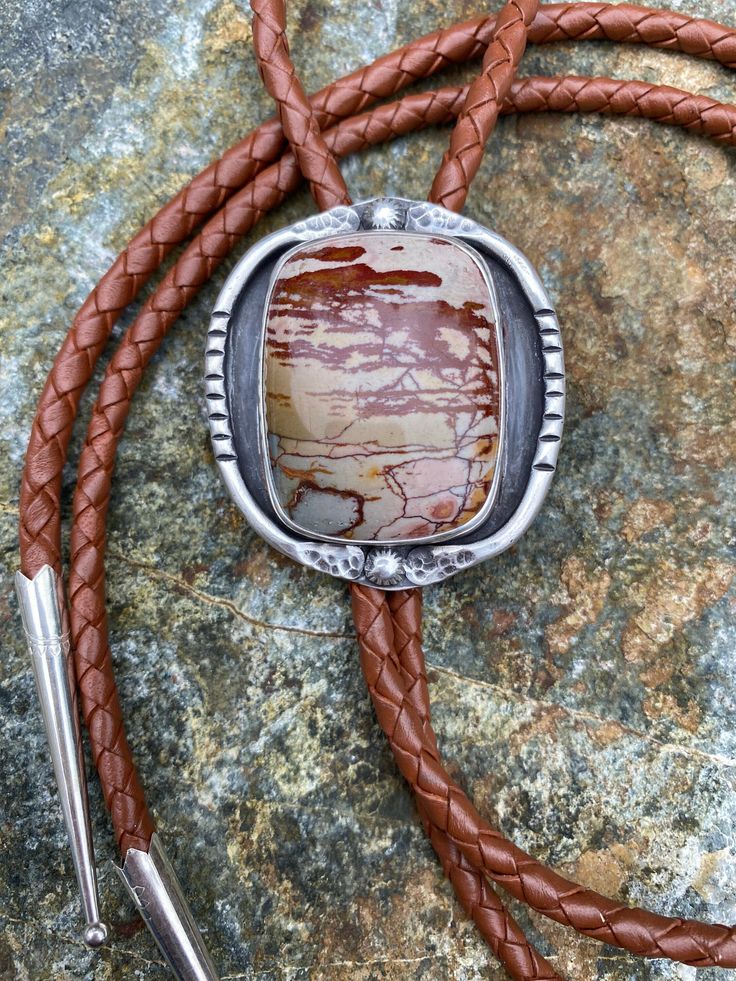 Colorful and fun jasper bolo tie. Surrounded by fine silver and sterling silver. On a 42 inch (hangs down 21 inches) braided leather cord with a handmade sterling slide and sterling tips. Western Lariat Jewelry As Gift, Western Style Lariat Jewelry As Gift, Western Style Lariat Jewelry For Gifts, Adjustable Concho Lariat Jewelry, Adjustable Brown Western Jewelry, Handmade Adjustable Western Bolo Ties, Western Style Lariat Jewelry With Adjustable Length, Western Style Necklace With Adjustable Cord, Handmade Bohemian Bolo Tie