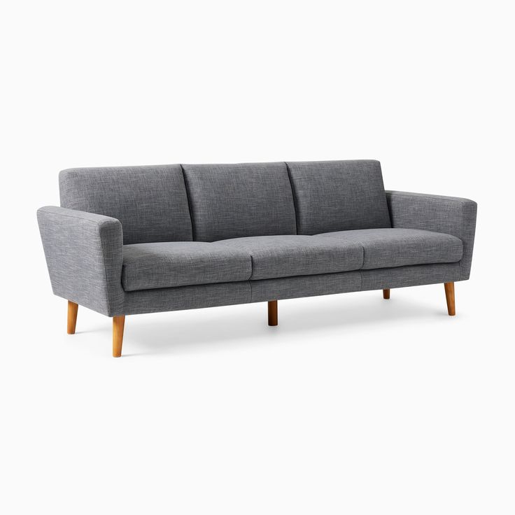 a gray couch sitting on top of a white floor