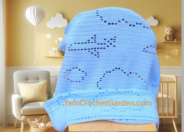 a crocheted blue blanket is on the floor in front of a baby's bed