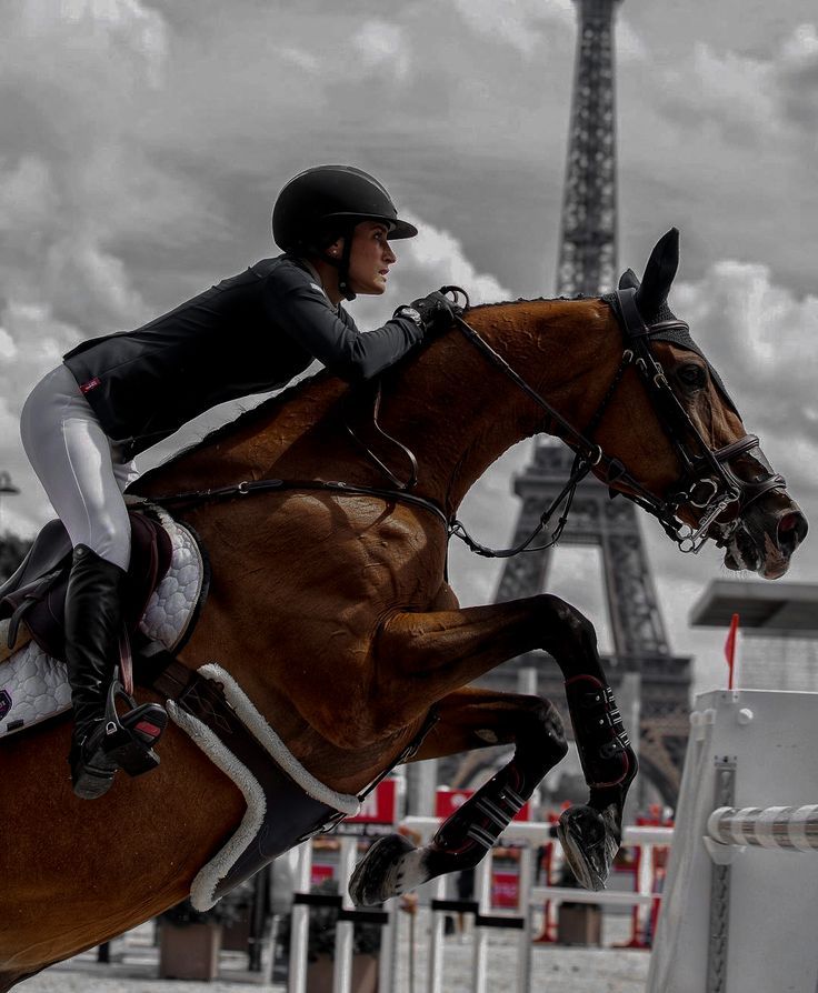 a woman riding on the back of a brown horse in front of the eiffel tower