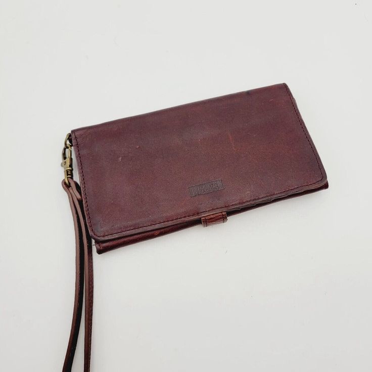 This is a vintage women's credit card wallet made by Duluth Trading Co. It is made of full leather in a solid brown color and features a snap closure. The wallet has a canvas fabric lining and includes a zipper and logo accents. It is designed to hold credit cards and has a money theme. The wallet is not handmade and was manufactured in China. Brown Wallets With Snap Closure For Everyday Use, Brown Wallet With Snap Closure For Everyday Use, Vintage Trifold Wallet With Coin Pocket, Vintage Trifold Wallet With Coin Pocket For Travel, Vintage Everyday Wallet With Coin Pocket, Vintage Wallets With Rfid Blocking For Daily Use, Vintage Trifold Wallet With Rfid Blocking For Travel, Vintage Wallet With Coin Pocket For Everyday Use, Vintage Rfid Blocking Wallets For Daily Use