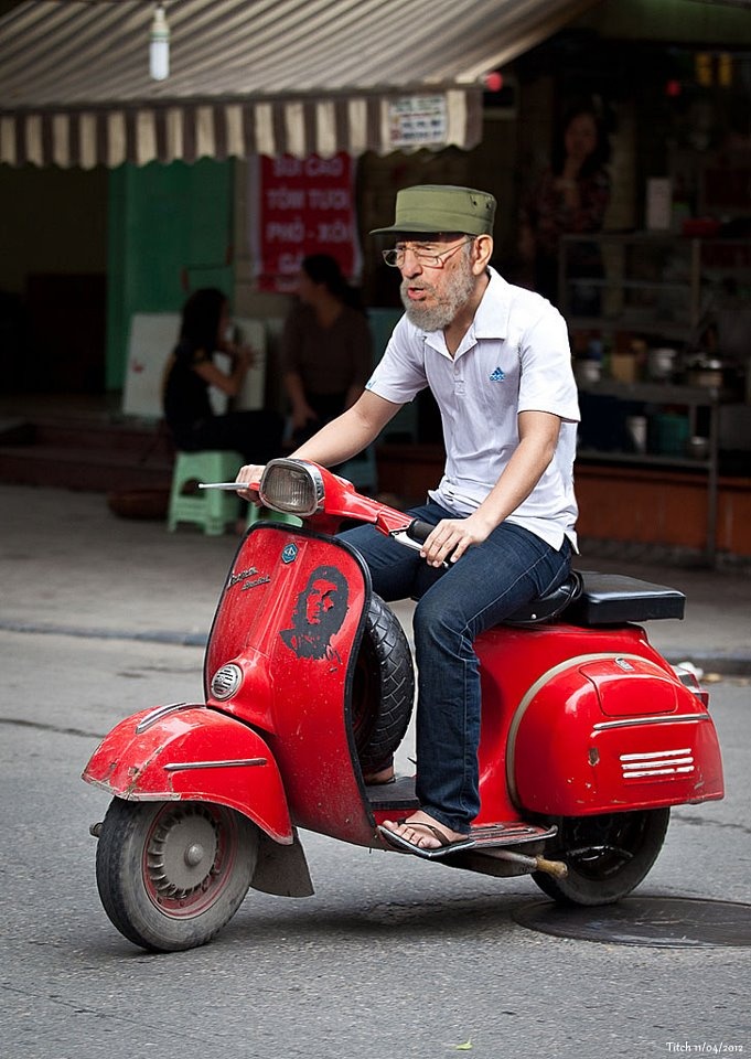 a man riding on the back of a red scooter