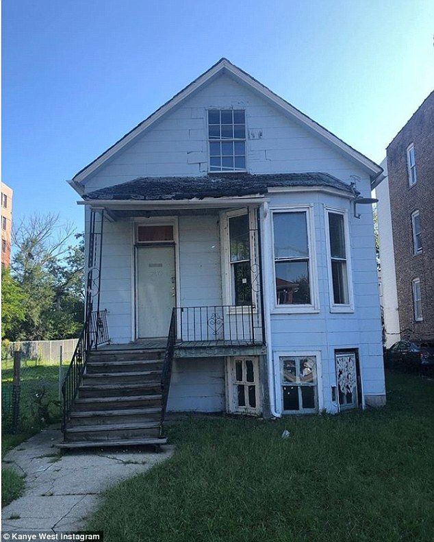 a white house with stairs leading up to the front door and second story window on one side