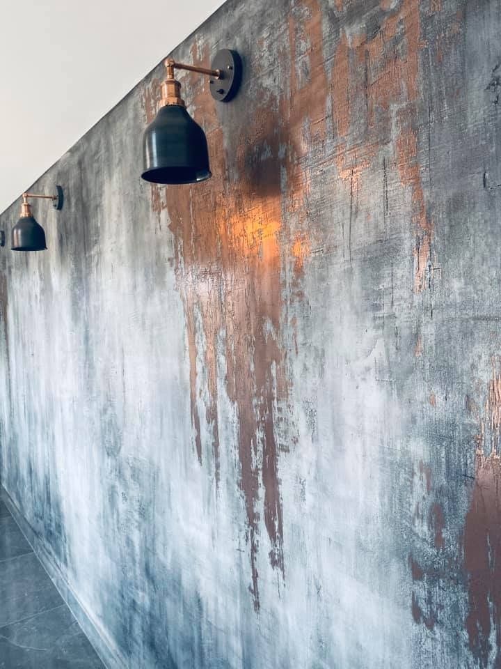 two black lamps are on the side of a wall