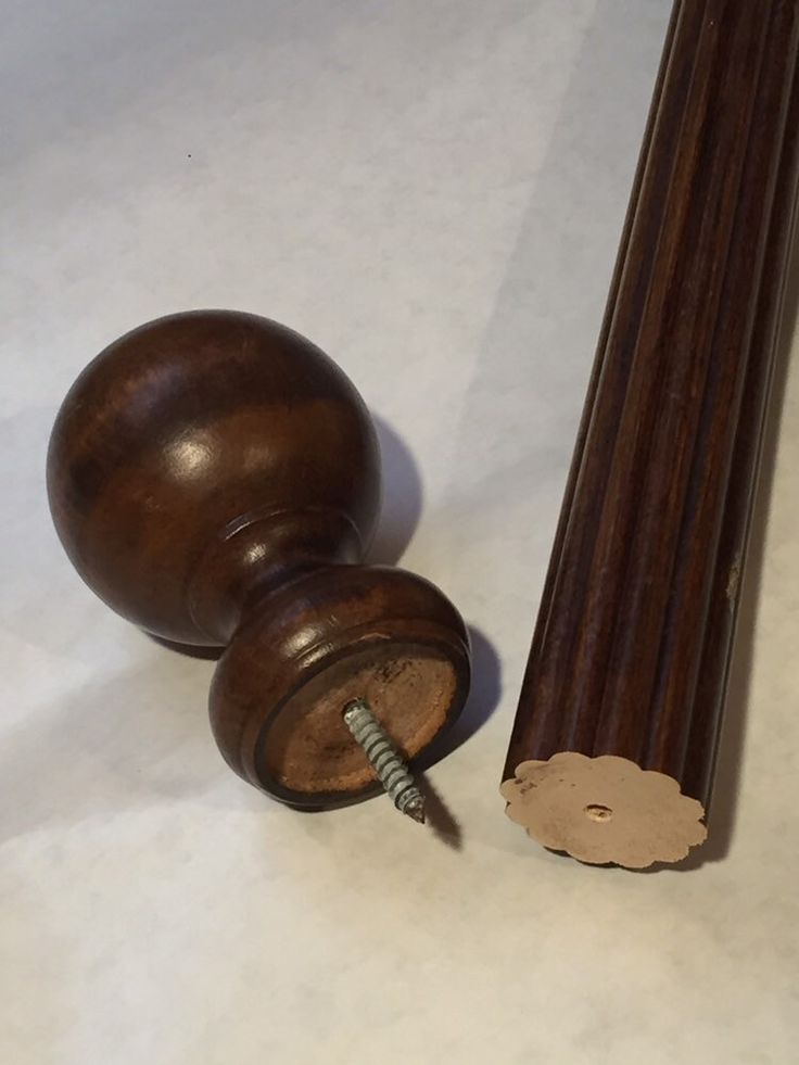 a close up of a wooden object with a screwdriver on the ground next to it