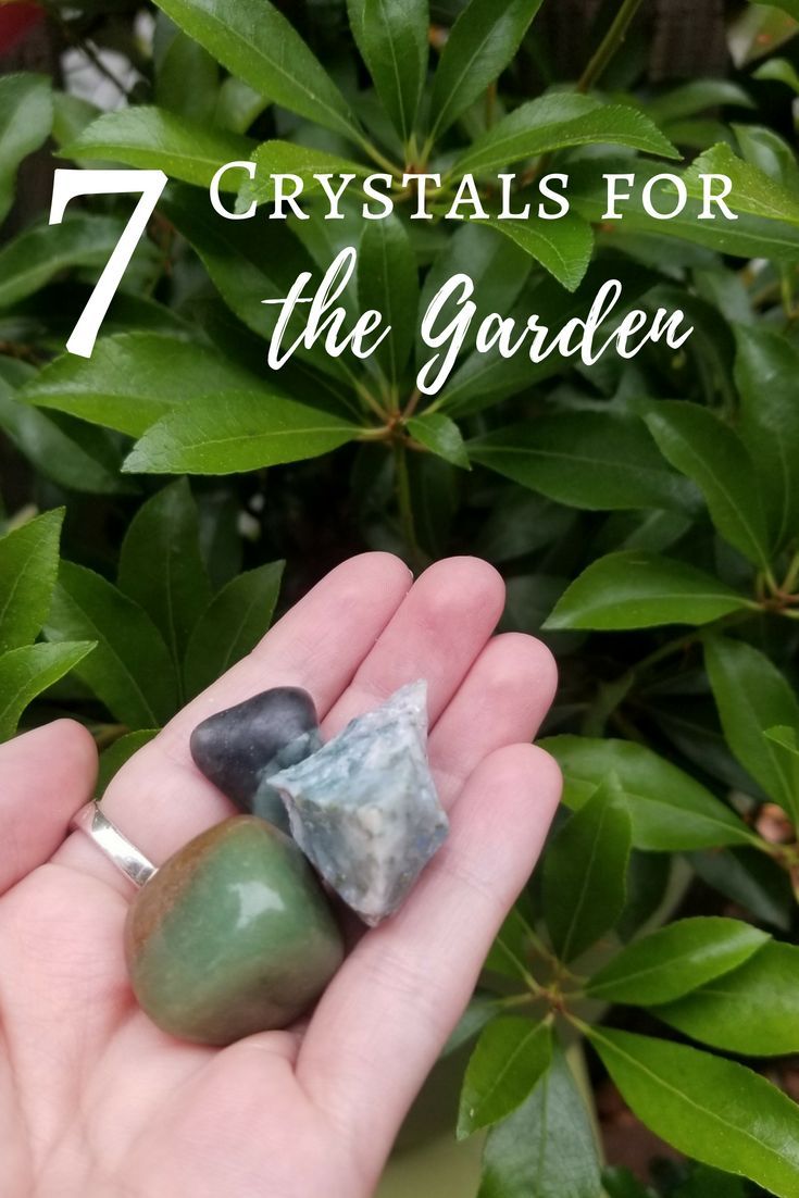 a person holding two rocks in their hand with the text 7 crystals for the garden