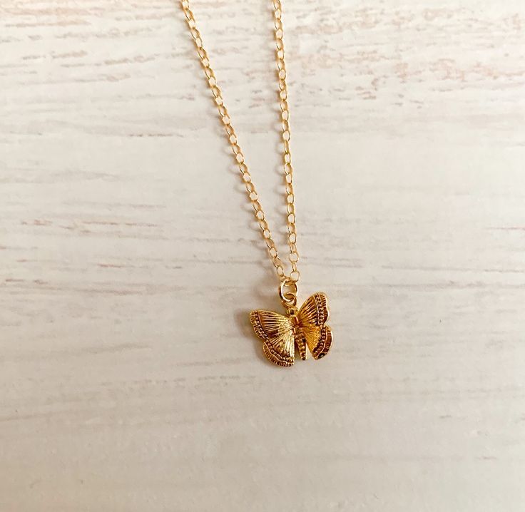 "BRENNAN   necklace features a dainty gold plated gold butterfly charm.   This is a shiny finish.  The chain is roughly 16\" long.   If you would like an extesion please see our listing to purchase extra length.   The chain is gold filled.  This is a beautiful lightweight piece.   The charm is roughly 1/4\". It's about the size of a dime.  It will come on a Haven jewelry card wrapped in a white  jewelry box with a bow. Perfect for gift giving. Follow Us on Social Media: https://www.instagram.com/havencurated/ https://m.facebook.com/havencurated/" Tiny Gold-plated Charm Necklaces, Tiny Gold Plated Charm Necklaces, Everyday Gold Butterfly-shaped Jewelry, Gold Butterfly Charm Pendant Necklace, Dainty Adjustable Gold Butterfly Necklace, Gold Plated Butterfly Necklace As Gift, Gold Necklace With Butterfly Charm As Gift, Gold Butterfly Necklace With Delicate Adjustable Chain, Gold Butterfly Necklace For Everyday Wear