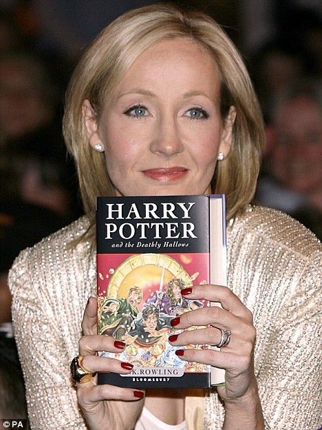 a woman holding up a harry potter book