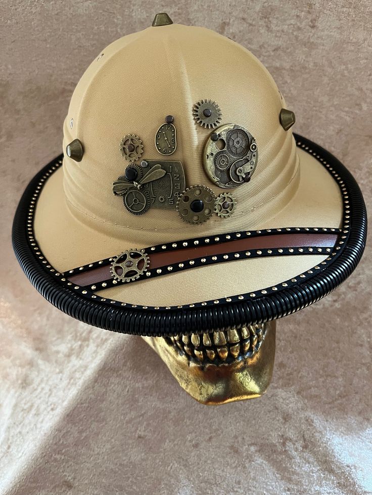 This hat is a costume-quality hat with fabric over something light (plastic? Foam?).    It has an elastic sweatband and ranges 55-58 cm.  It fits my oval 22 inch head fine.   Can be remade on request, though the fittings will vary with materials.   The hat is embellished with a variety of metal gears, studs, etc., with corrugated piping around the edge. More hats available at tricornes.shop without added ETSY fees. Adjustable Retro Costume Accessories For Costume Party, Steampunk Adjustable Masks And Prosthetics For Festivals, Adjustable Steampunk Masks And Prosthetics For Festival, Adjustable High Crown Top Hat For Themed Events, Adjustable Brimmed Costume Accessories For Cosplay, Adjustable Cap For Costume, Adjustable Costume Cap, Steampunk Adjustable Costume Hats And Headpieces, Novelty Costume Hat With Adjustable High Crown