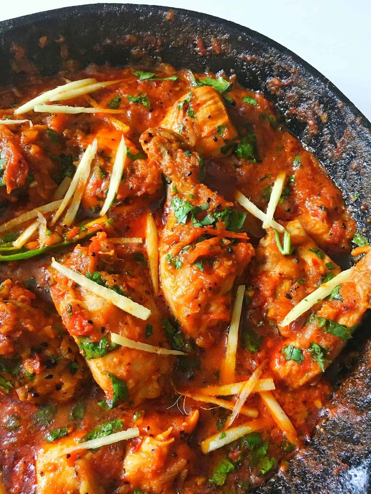 a skillet filled with meat covered in sauce and cheese