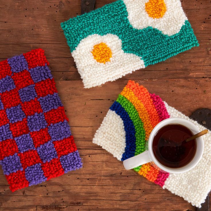 two crocheted placemats on a wooden table next to a cup of coffee