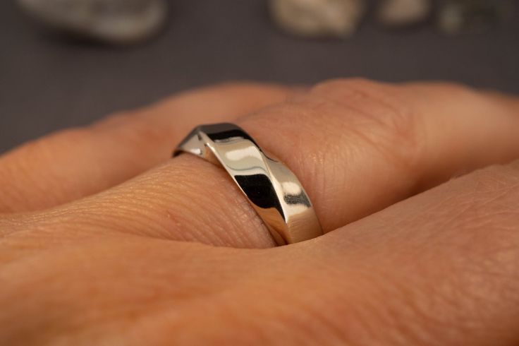 a person's hand with a silver ring on it